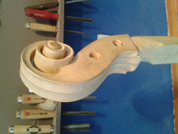 Volute d'instrument en cours de sculpture, à l'établi